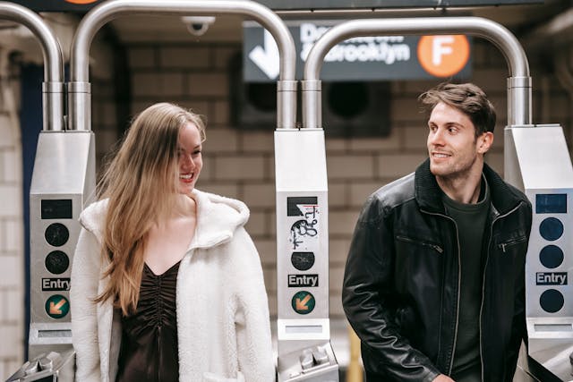 Zelfverzekerde vrouw lacht ontspannen tijdens een ontmoeting met haar ex op een metrostation.