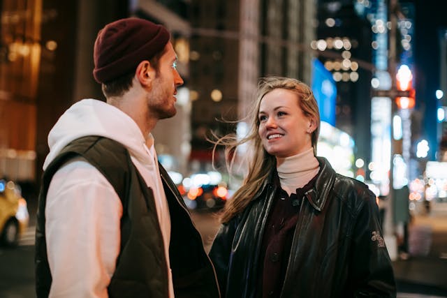 Man en vrouw wisselen een veelzeggende blik uit terwijl ze elkaar naderen.