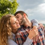 Man en vrouw die elkaar speels kussen, ontspannen samen