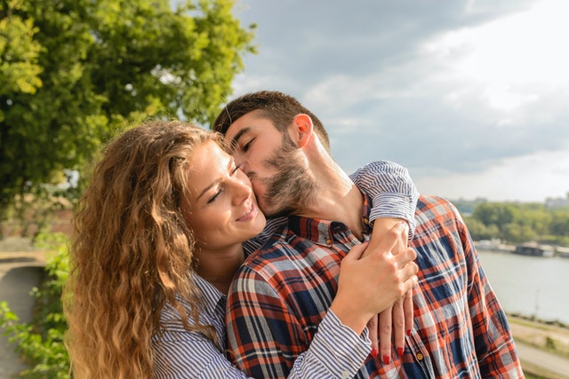 Man en vrouw die elkaar speels kussen, ontspannen samen