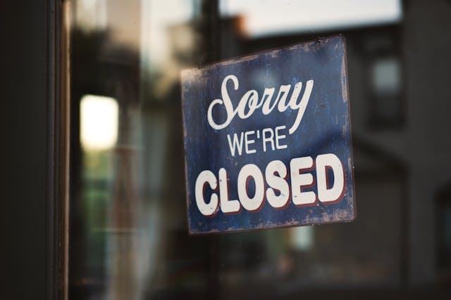 Close-up van een deur met een bordje Sorry we're closed.