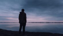 Silhouet van een persoon die rust zoekt bij het water nadat de ex heeft gezegd dat het nooit meer goedkomt.
