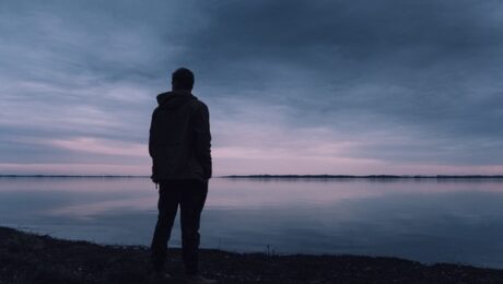 Silhouet van een persoon die rust zoekt bij het water nadat de ex heeft gezegd dat het nooit meer goedkomt.