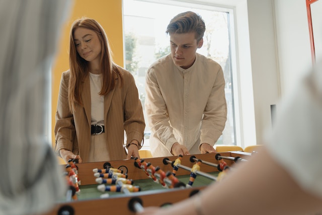 Man en vrouw spelen samen tafelvoetbal, symbool voor de friendzone na een relatiebreuk.